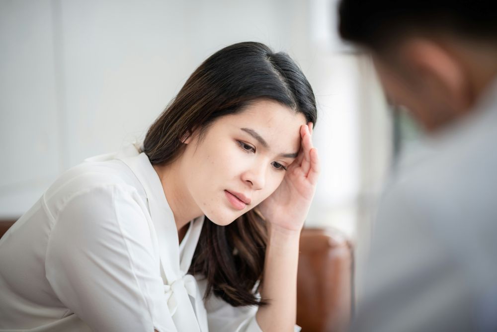 Woman in therapy office looks defeated but is getting the help she needs through trauma therapy