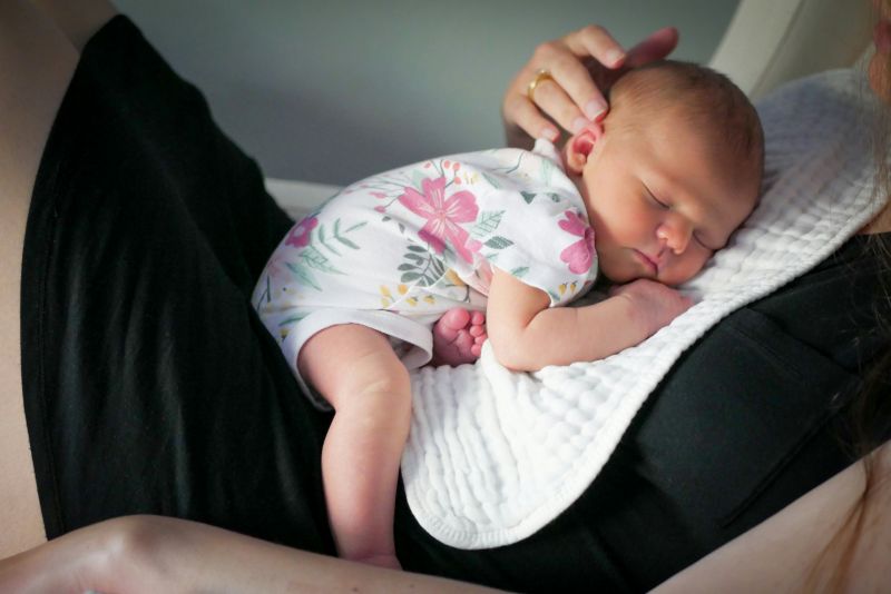 New mom holds baby on chest while being impacted by postpartum depression.