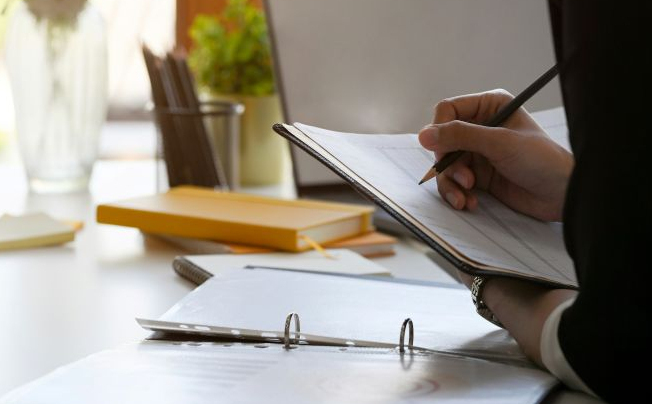 A woman updates her planner at her desk as she schedules clinical consultations in Alexandria, Virginia.