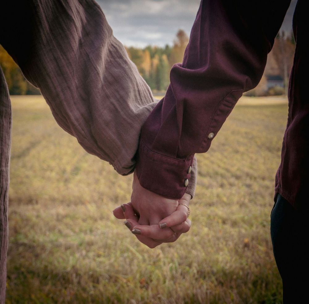 Couple holds hand in the fall outdoors after receiving couples therapy in northern Virginia at Brickel & Associates