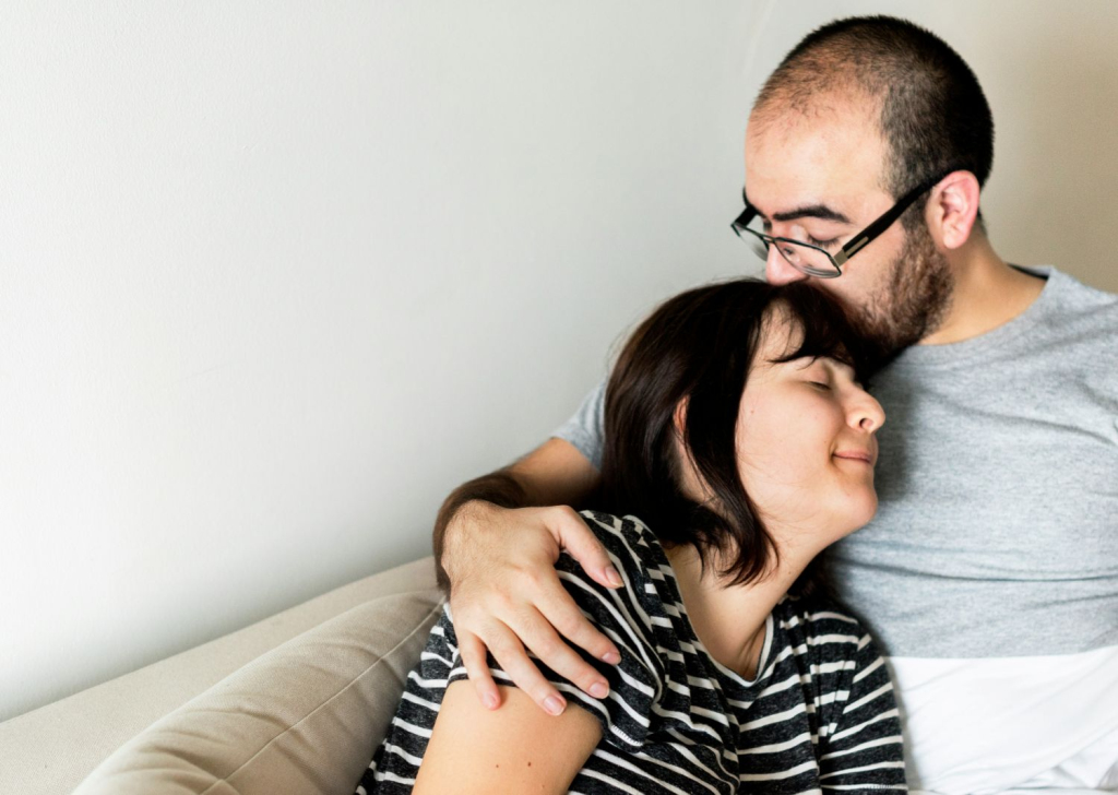 A couple supports one another while sitting in a therapy session guided by relational therapy.