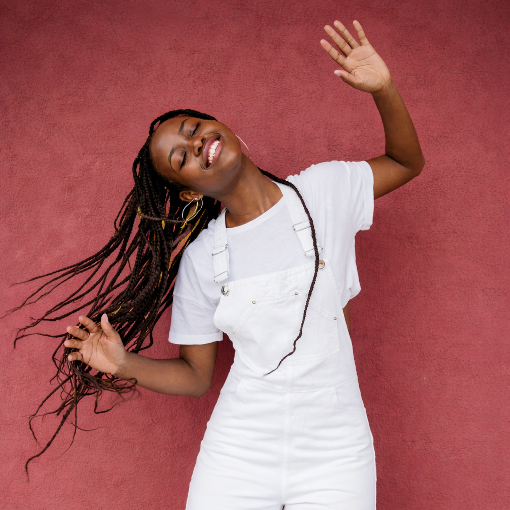 A African American woman in a white outfit stands and moves her body happily during a sensorimotor Therapy session.