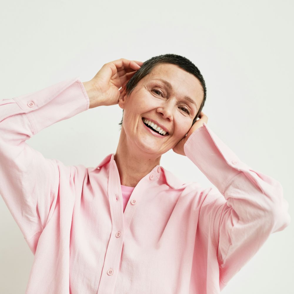 A older woman smiles in confidence as she has been given the space to handle difficult emotions through emotional regulation.