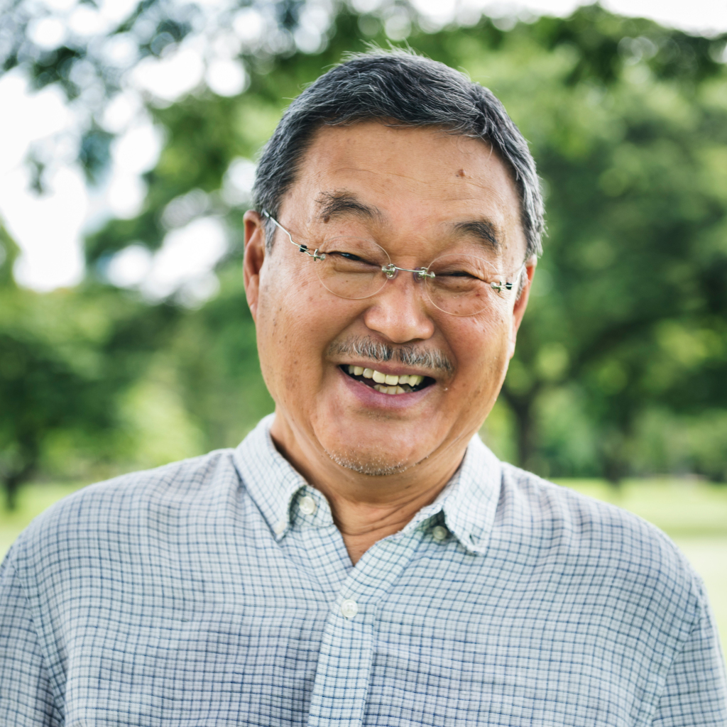 Older Asian gentleman smiles after receiving individual therapy at Brickel & Associates