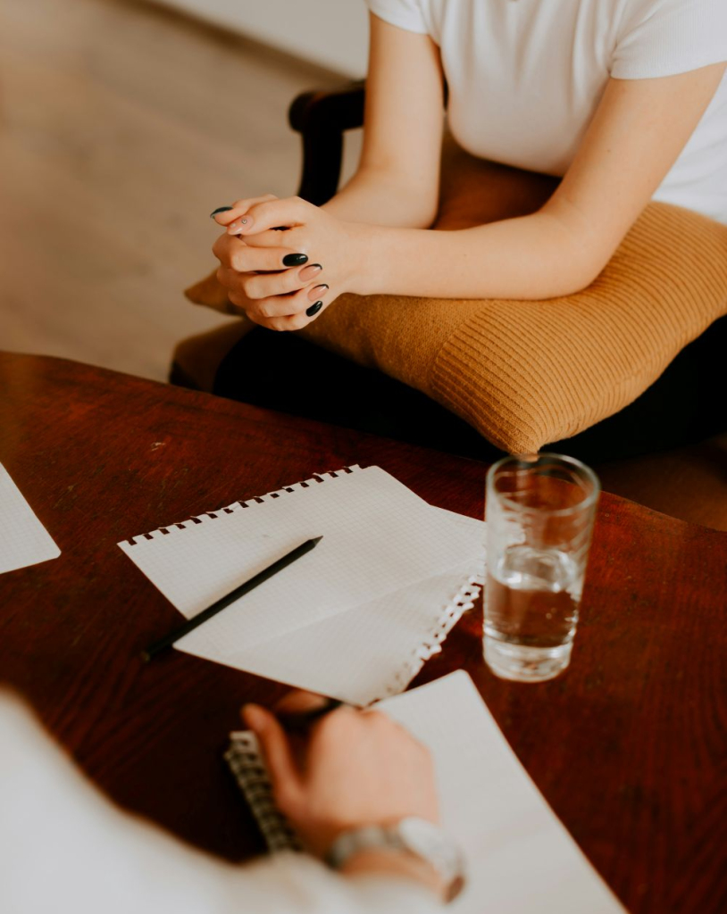 A woman sits across from a therapist to receive in-person therapy at Brickel and Associates